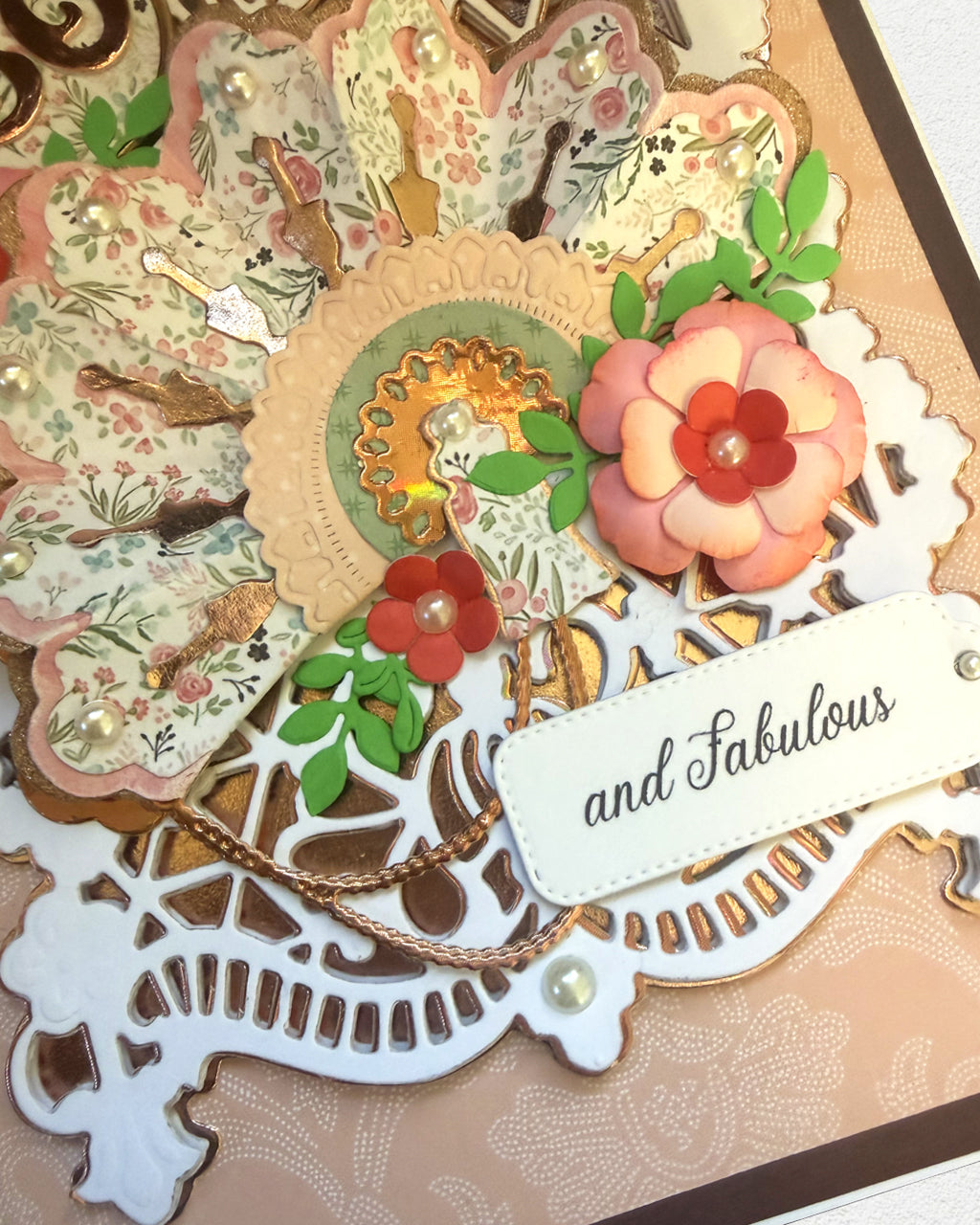 Decorative card with floral elements and a 'and Fabulous' tag on a textured background