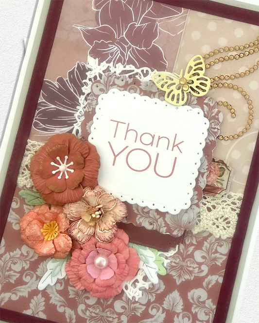 Close-up of gold butterfly and pearl strand above "Thank YOU" sentiment frame