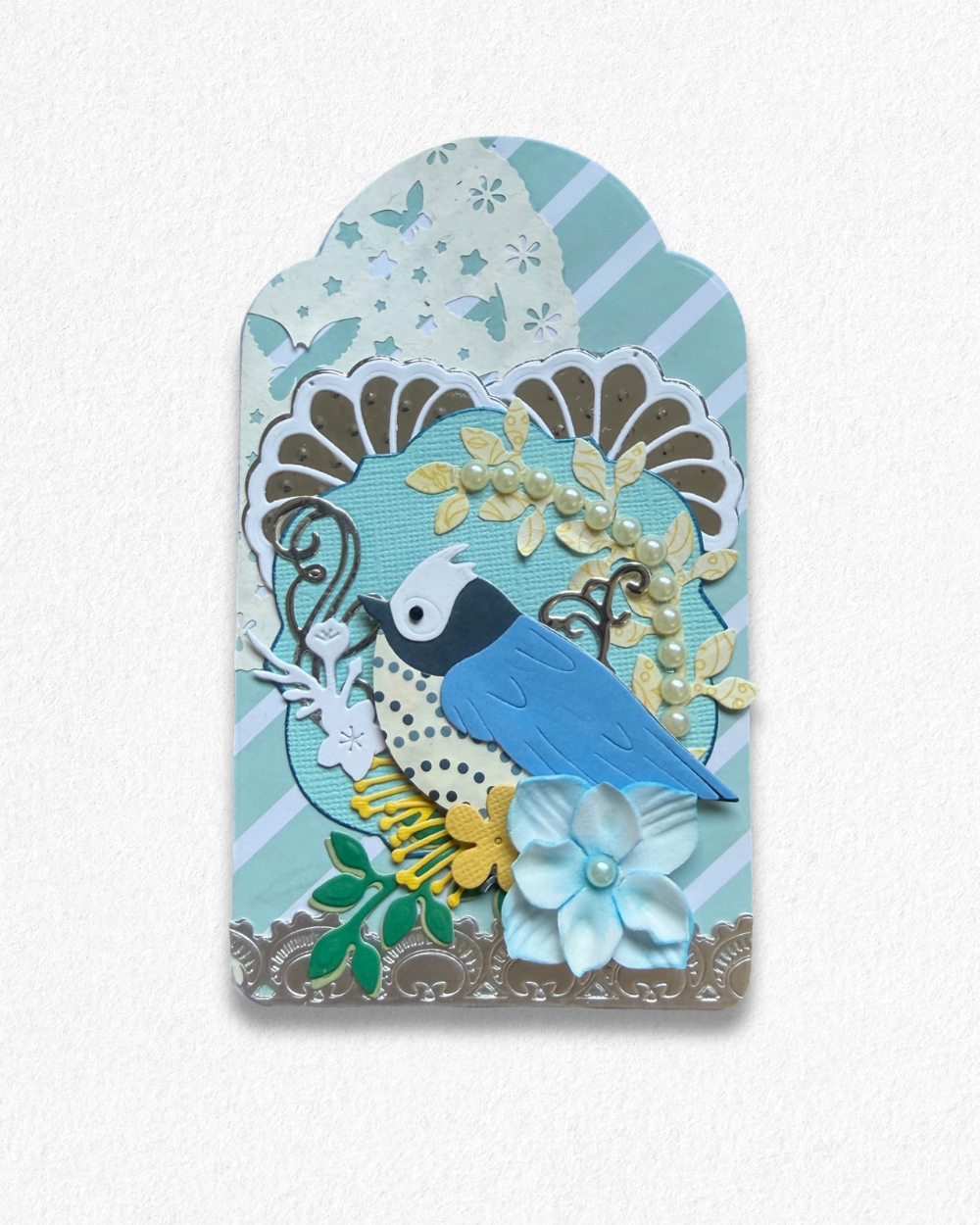 Handmade mini card by Del Cards NZ featuring a die-cut bird with floral details on a mint striped background.