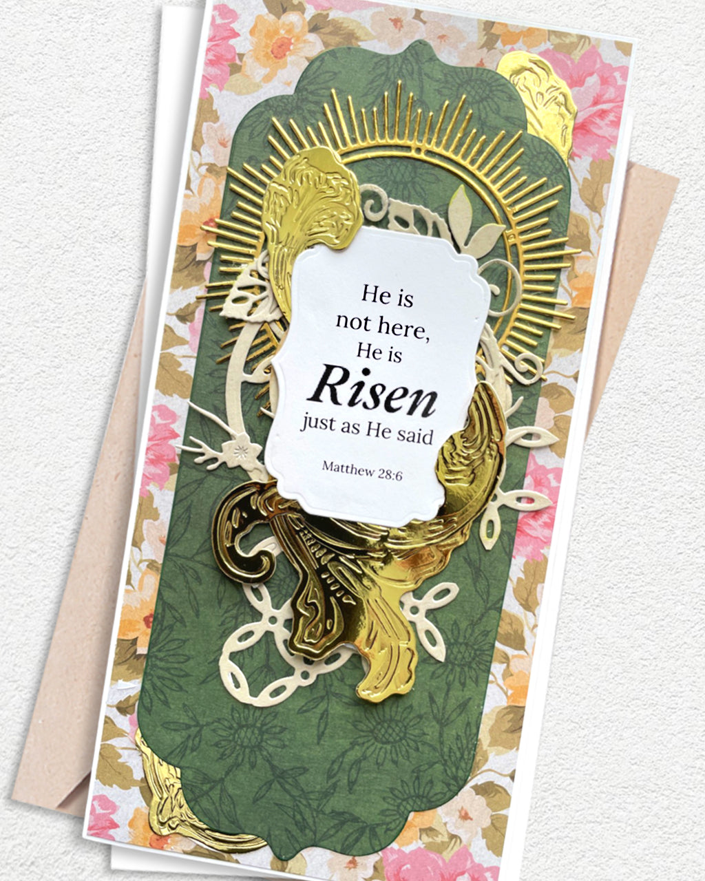 Close-up of Christian Greeting Card showing gold sunburst rays and ornate die-cut flourishes over deep green panel