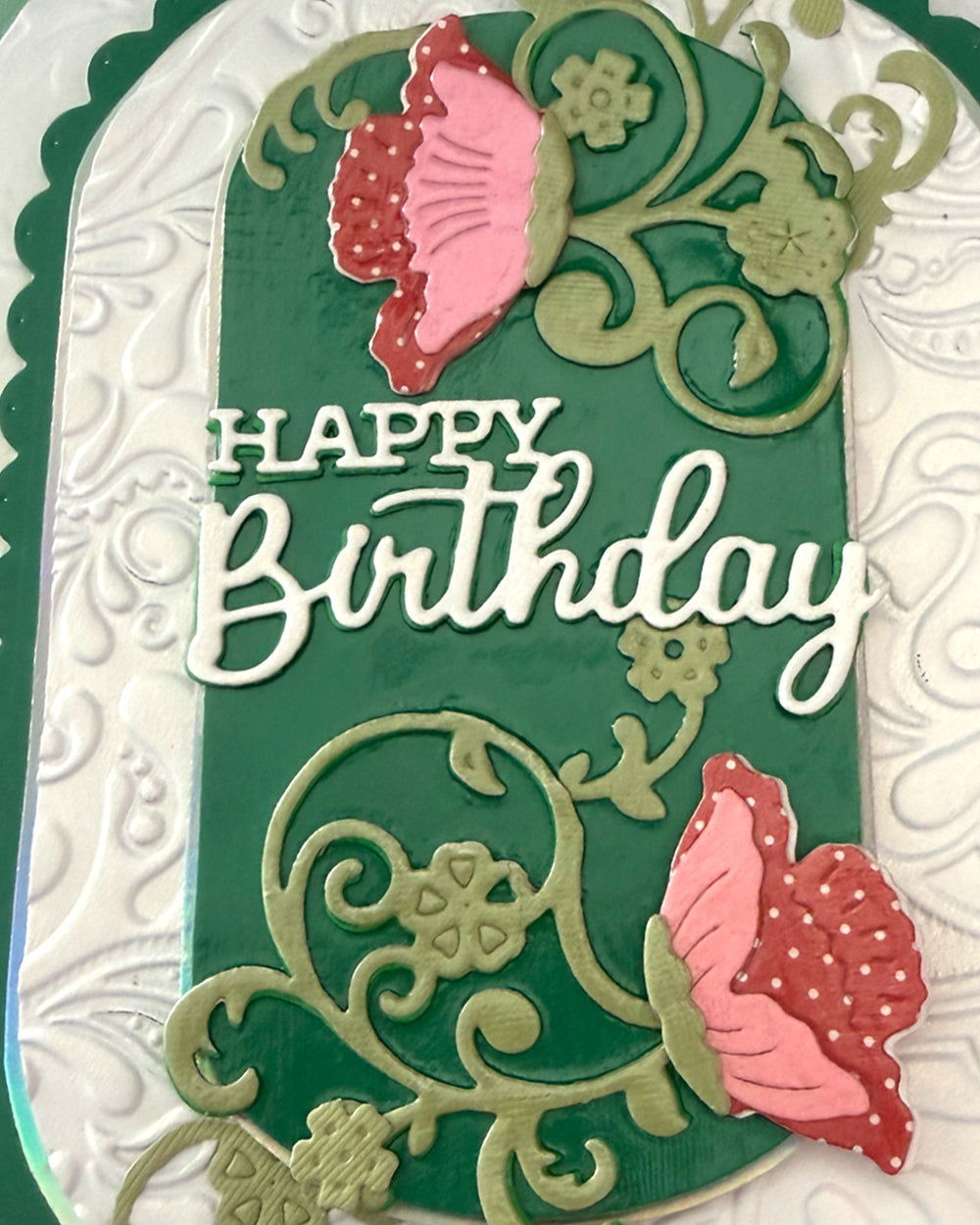 Detail of layered floral vine die-cuts and a dimensional pink poppy bloom on an emerald and embossed cream birthday card
