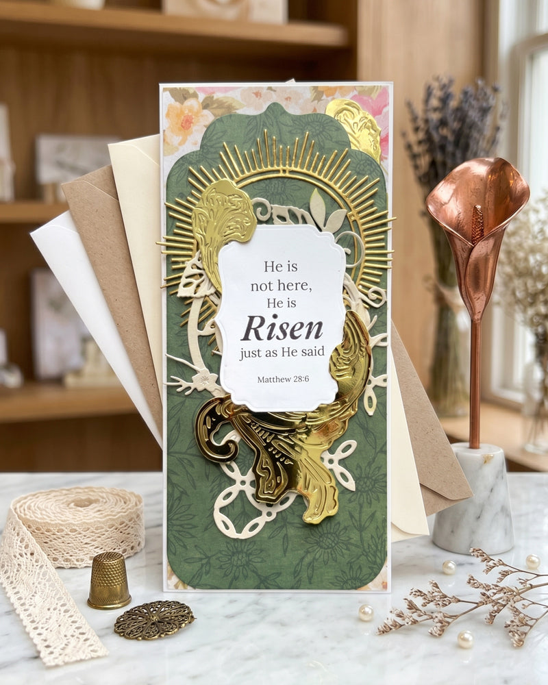 Handmade Christian Greeting Card displayed upright on a wooden surface beside dried florals, showing full card design with gold sunburst and floral layers