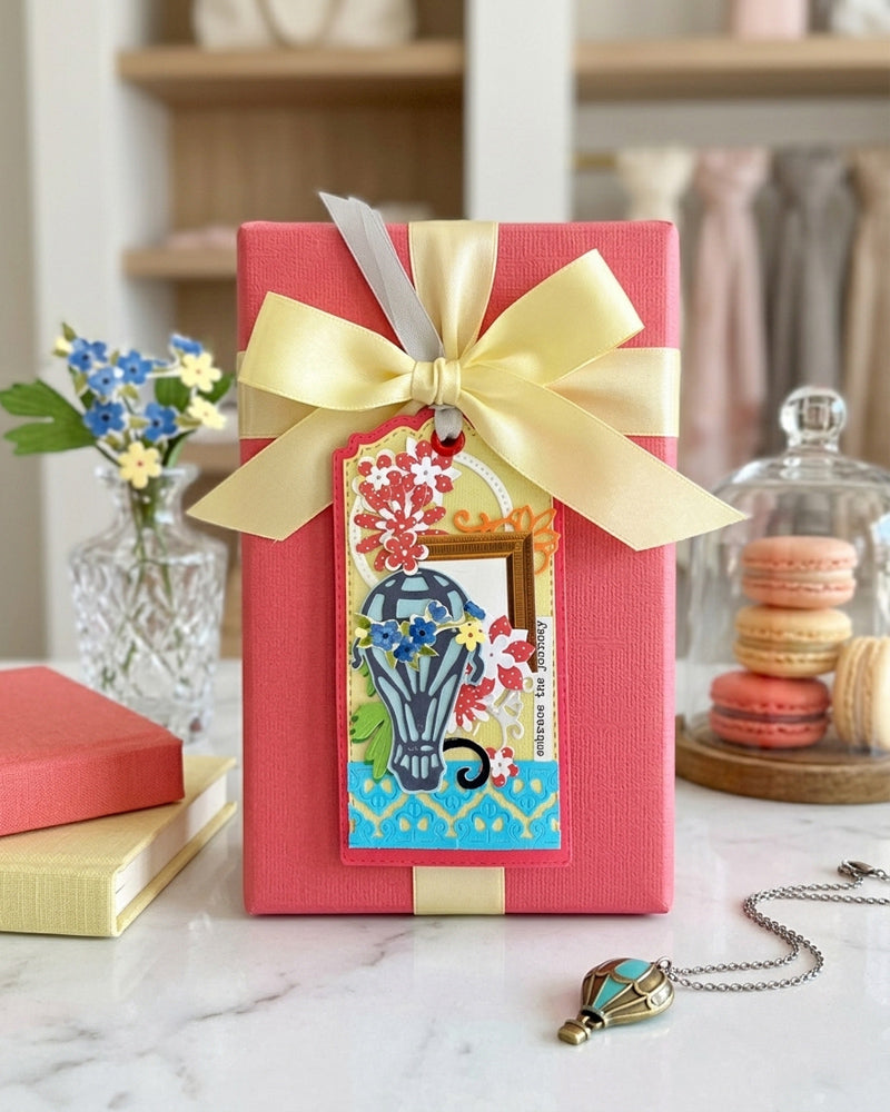 Luxury handmade gift tag styled with a red gift bag and gold satin bow — Del Cards NZ handmade gift tags complement any special occasion gift