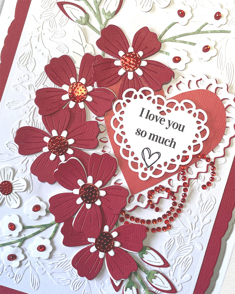Close-up of lace-edged heart panel reading "I love you so much" surrounded by deep red dimensional flowers and crystal embellishments