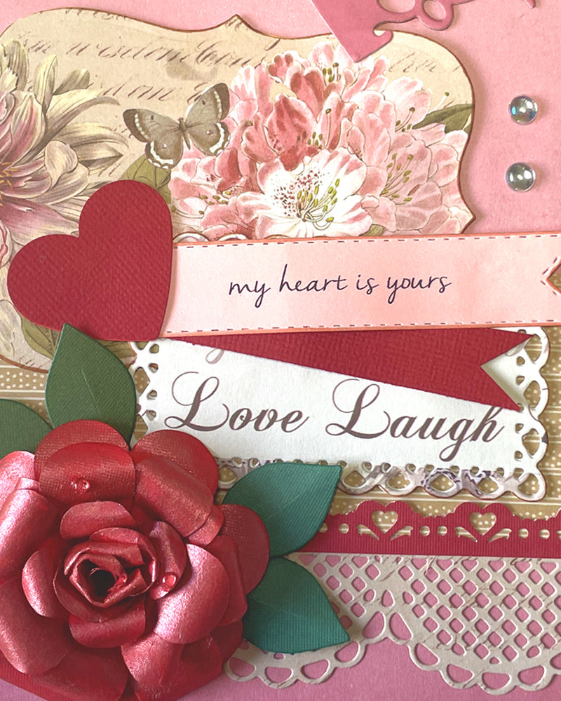 Close-up of dimensional deep red rose with lace doily, banner reading "my heart is yours," and "Love Laugh" sentiment on layered pink card