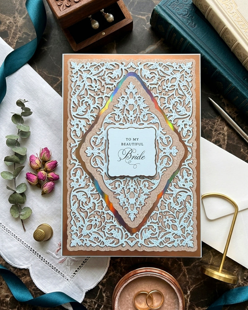 Decorative card with intricate design on a textured surface with ribbons and flowers.