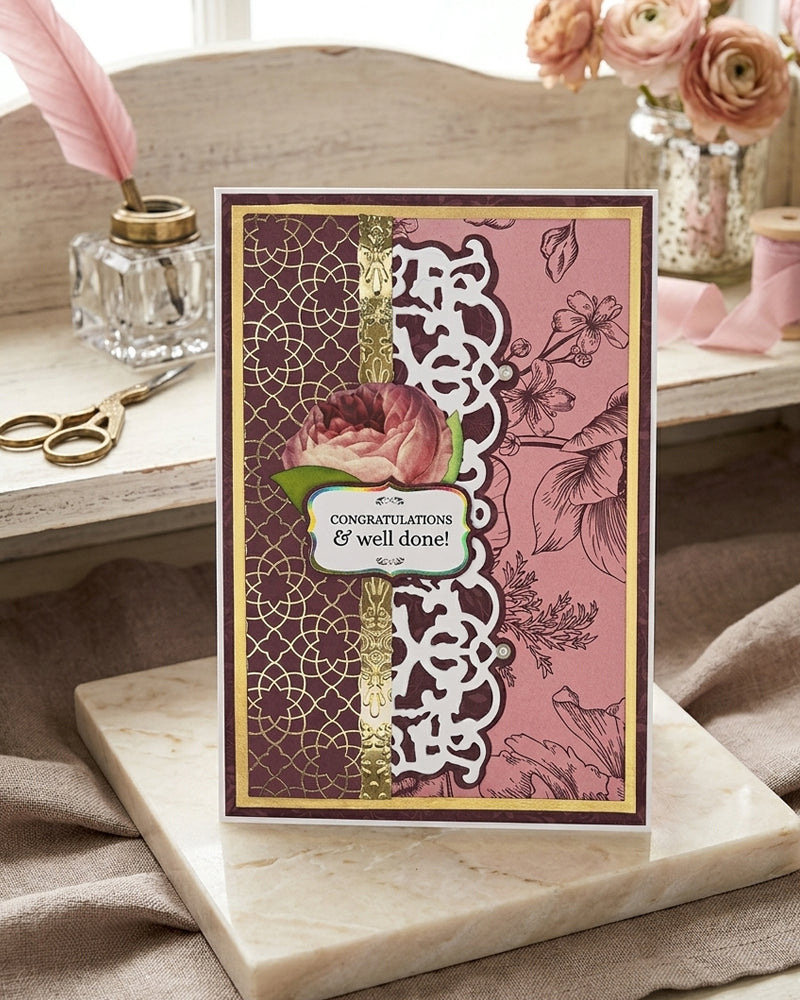 Decorative card with floral design and text on a marble surface with flowers and scissors in the background. Made in NZ by Del Cards.